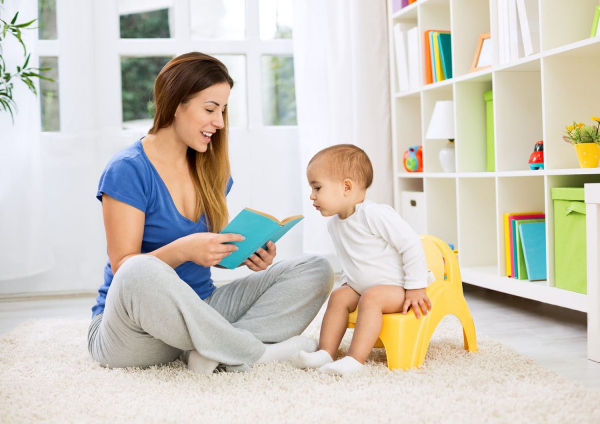 elimination communication, baby sitting on potty with mom reading book