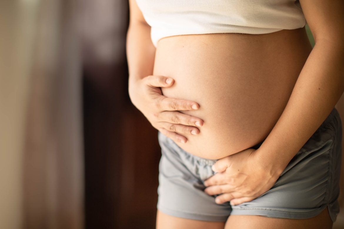 weird pregnancy symptoms: a pregnant woman holding her bladder